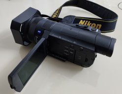 Видеокамера Sony 4K Handycam FDR-AX100E + оригинальный фонарь Sony + Сумка для камеры + фильтр UV Zeiss + 3 батареи (2 из них большой ёмкости) + Зарядное Sony + пульт дистанционного управления + карандаш для чистки объектива + карта памяти (скоростная) 64GB. image 1
